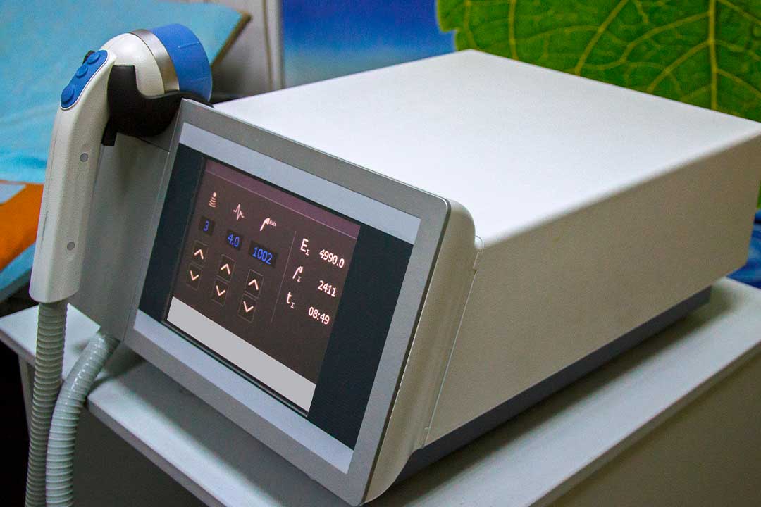 A shockwave therapy medical device is placed on a table, showcasing advanced medical technology for treatment.