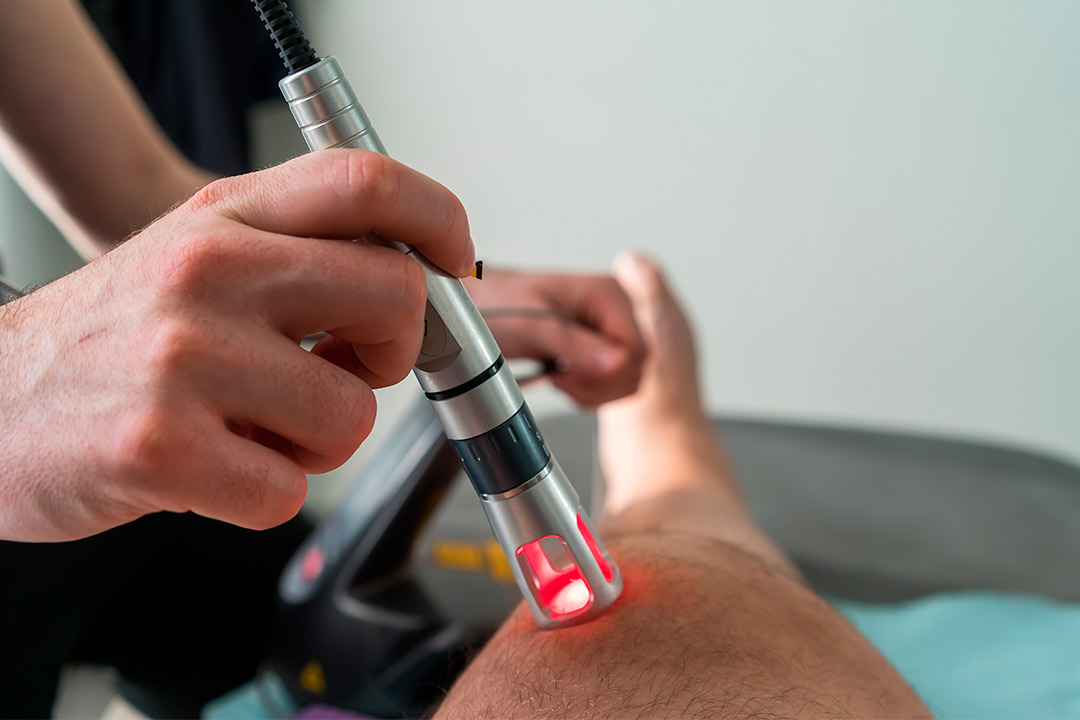 A person receiving Class IV laser treatment on their leg for fall-related issues.